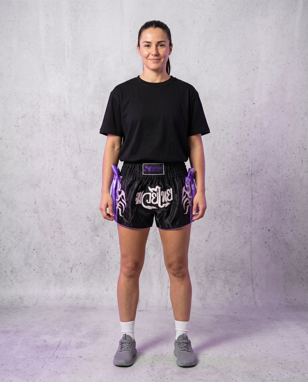 Model wearing Nova black and purple satin Muay Thai shorts with Nova Sports waistband, full-length front view — Muay Thai shorts available in Mauritius — Shorts from Nova Sports Mauritius
