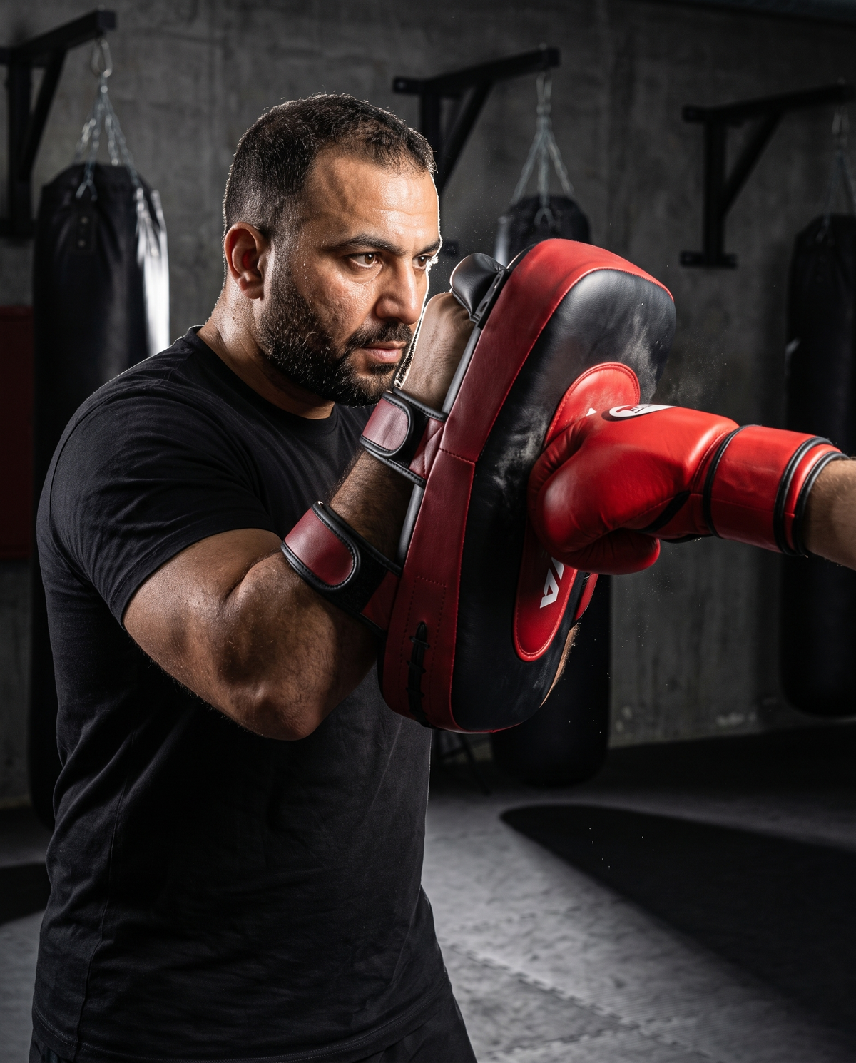 Coach catching a strike on a NOVA black and red rexine arm pad during pad work — Arm Pads from Nova Sports Mauritius
