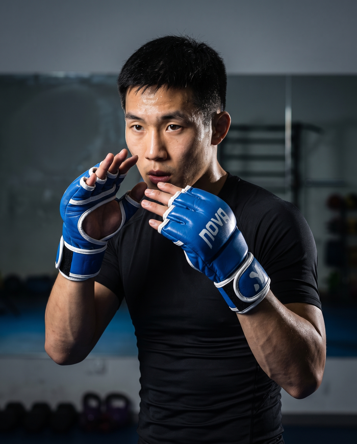 Model in open-palm guard wearing NOVA blue MMA grappling gloves — Gloves available in Mauritius
