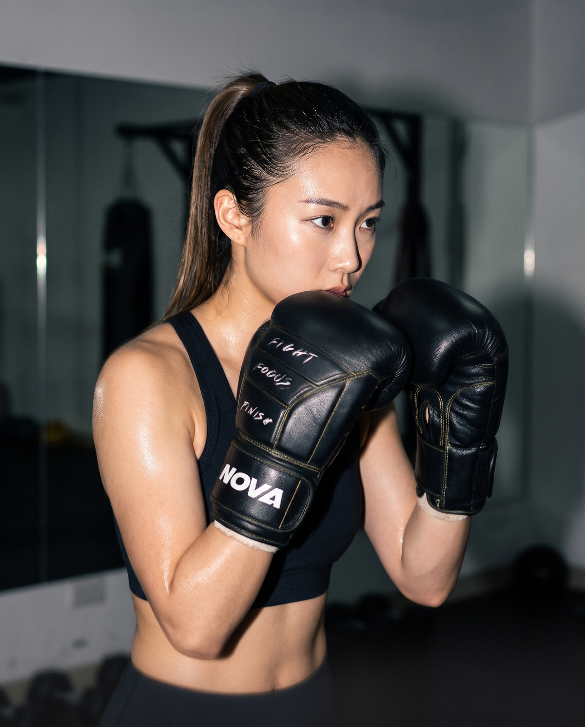 Model shadow-boxing wearing NOVA black boxing gloves with yellow stitching — Gloves from Nova Sports Mauritius
