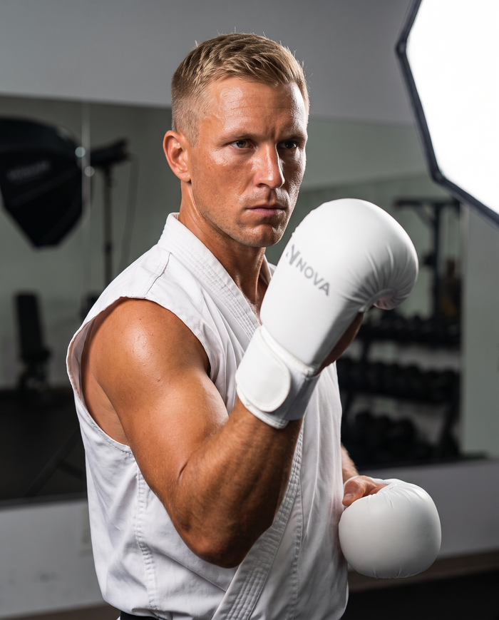 Karate athlete in kumite stance wearing NOVA white karate gloves — Gloves available in Mauritius
